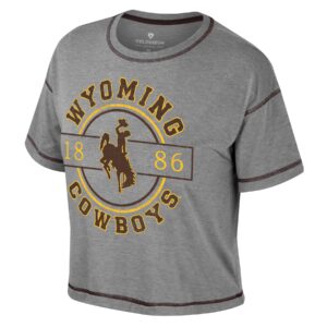 grey short sleeve t-shirt with circular design on front. Design is arced wyoming, with bucking horse in center and cowboys near bottom. In center is a brown and gold circle with 1886 in gold. all text is brown with gold outline.