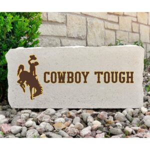 16x7 inch concrete stone with bucking horse on right side with cowboy tough to the left. All text is brown with gold outline.