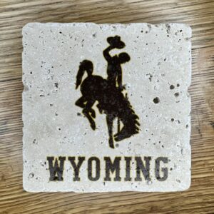 4x4 inch coaster with bucking horse in brown with gold outline in center, wyoming in brown with gold outline near bottom.
