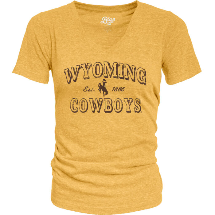 womens v-neck t-shirt in gold. On front, in all brown text, arced wyoming with bucking horse under and cowboys at bottom. Design is centered.