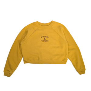 gold cropped crewneck with small, embroidered design on center chest. arced wyoming with bucking horse under and cowboys at bottom. all in brown