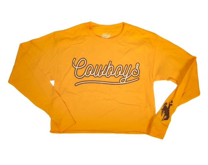 Gold long sleeve crop top with script bubble text, cowboy in white with brown outline. Design is large on center chest. Brown bucking horse on left wrist