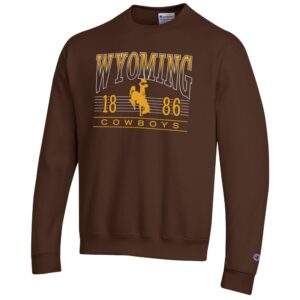 Brown crewneck sweatshirt with design center chest. arced wyoming in white outline with top half filled with gold, bucking horse, 1886, cowboys under arc in gold