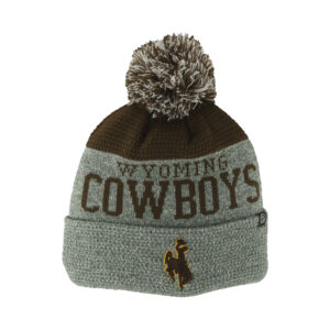 brown and grey knit beanie with pom-pom on top. Grey base around head with Wyoming cowboys in brown and cuffed bottom with brown bucking horse on one side