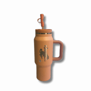 30oz travel tumbler. peach colored with straw lid. has etched bucking horse on one side