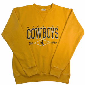 gold crewneck with design center chest. design is small brown wyoming lettering with big cowboys lettering below. has cursive est 1886 at bottom with bucking horse in middle