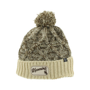 brown and cream speckled beanie with pom on top. has cream band around bottom. on band is a cursive wyoming with bucking horse below center