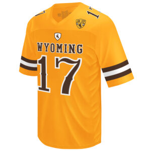 front of gold football jersey, white and brown stripes on sleeves, brown shield with brown bucking horse above gold word Wyoming above brown number 17. has commemorative patch on left chest