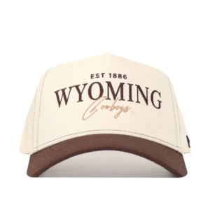 cream hat with brown bill. has brown embroidered est 1886 on front panel with wyoming lettering below and tan cowboys script below that