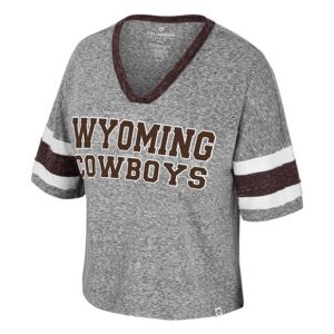 grey women's v-neck cropped tee shirt. has jersey type stripes on sleeve in white and brown. design on center chest is brown wyoming cowboys lettering stacked with white outline.